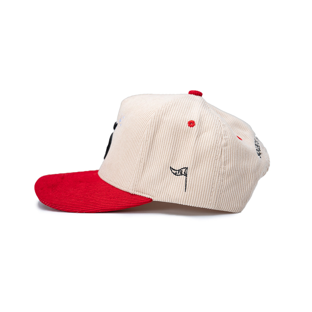 Cap with red brim and white bill featuring embroidered designs on a white background