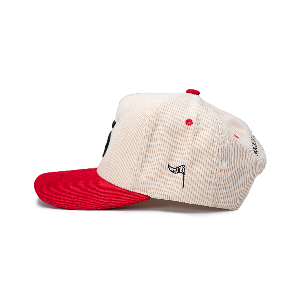 Cap with red brim and beige body on a white background
