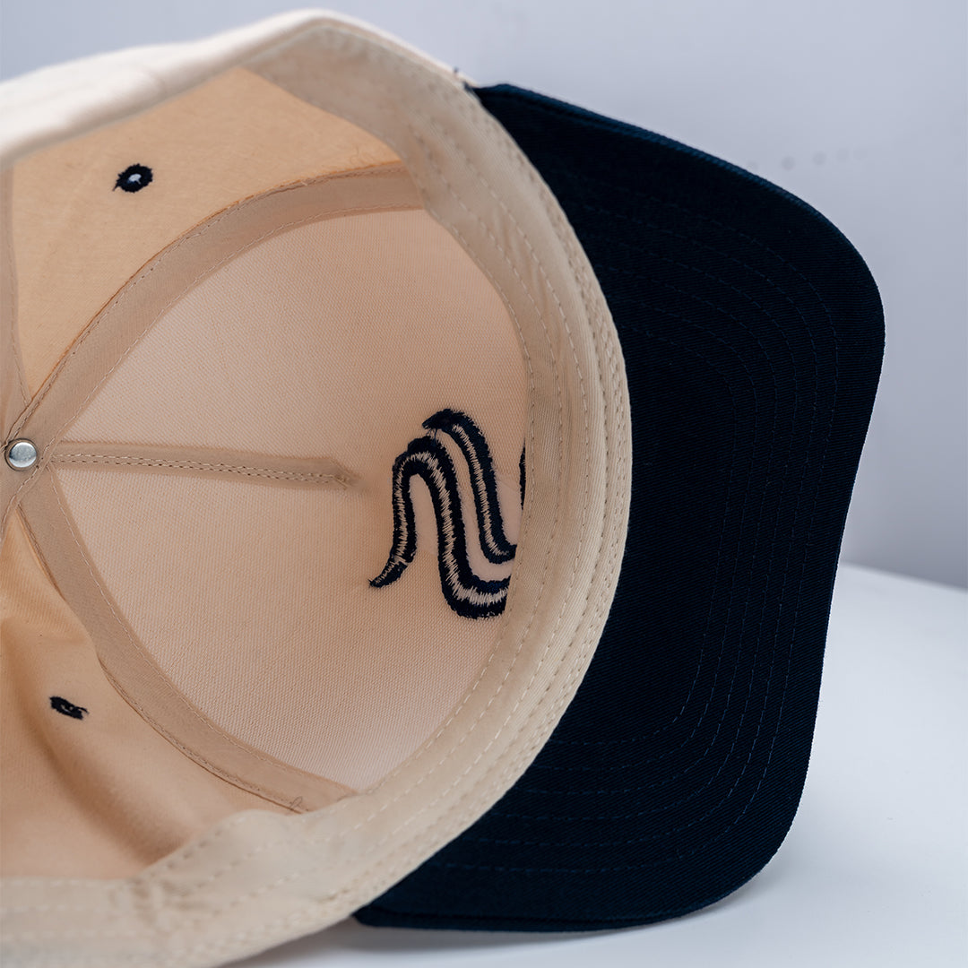 Close-up of two caps, one beige and one black, on a light gray background.